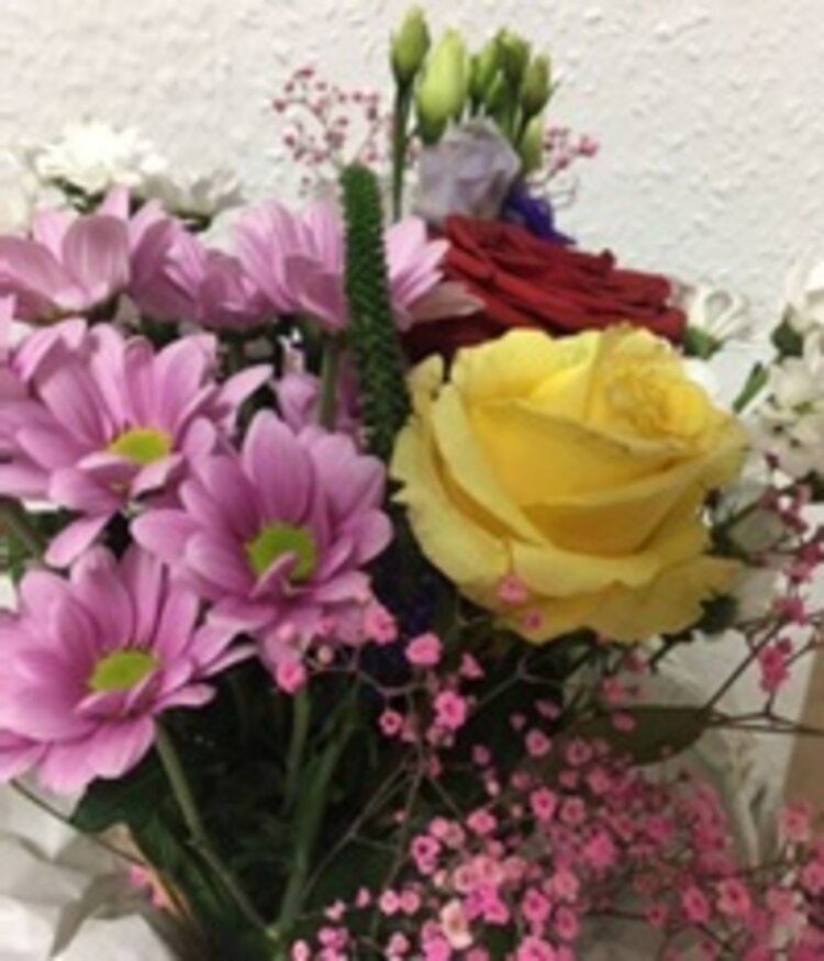 Farbenfroher Blumenstrauß mit gelber Rose und rosafarbenen Blumen. 