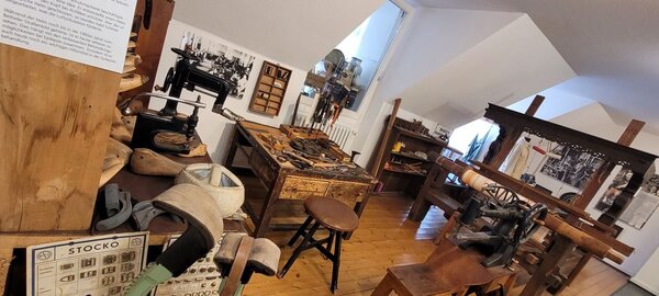 Ausstellung historischer Werkzeuge und Maschinen in einem Museum, darunter Webstühle und andere Geräte.