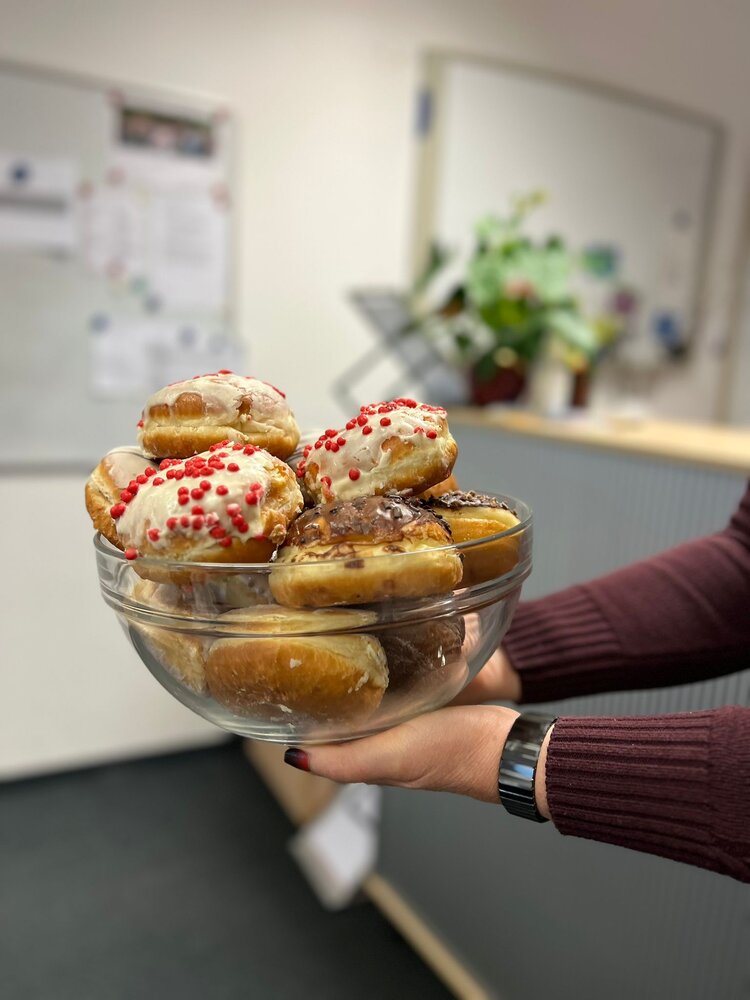 Eine Frau hält ein Glasgefäß mit Gebäck in Bild.