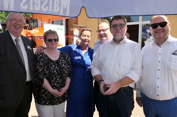 Sechs Teilnehmende des Seminars stehen unter einem Sonnenschirm und posieren für ein Gruppenfoto.