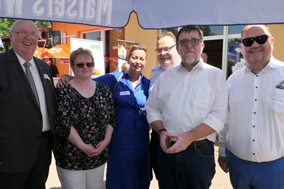 Sechs Teilnehmende des Seminars stehen unter einem Sonnenschirm und posieren für ein Gruppenfoto.