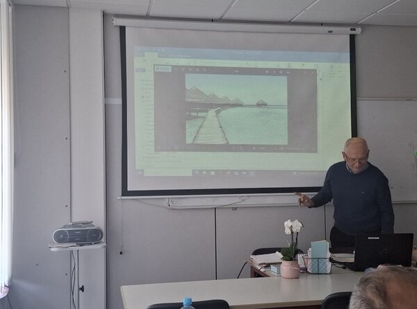 Ein männlicher Teilnehmer steht vor am Whiteboard im Unterrichtsraum und hält seine Präsentation vor seinen Mitteilnehmenden des B2-Sprachkurses an den Euro-Schulen Magdeburg.