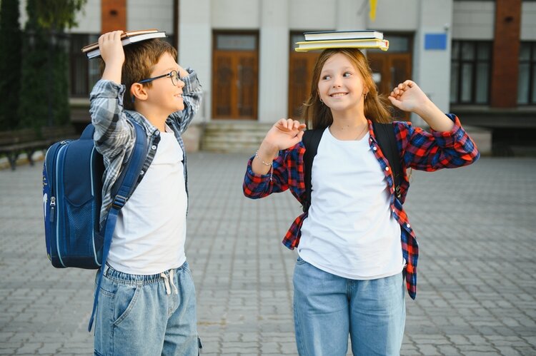 Porträt von lächelnden Schulkindern, die auf dem Schulhof stehen.