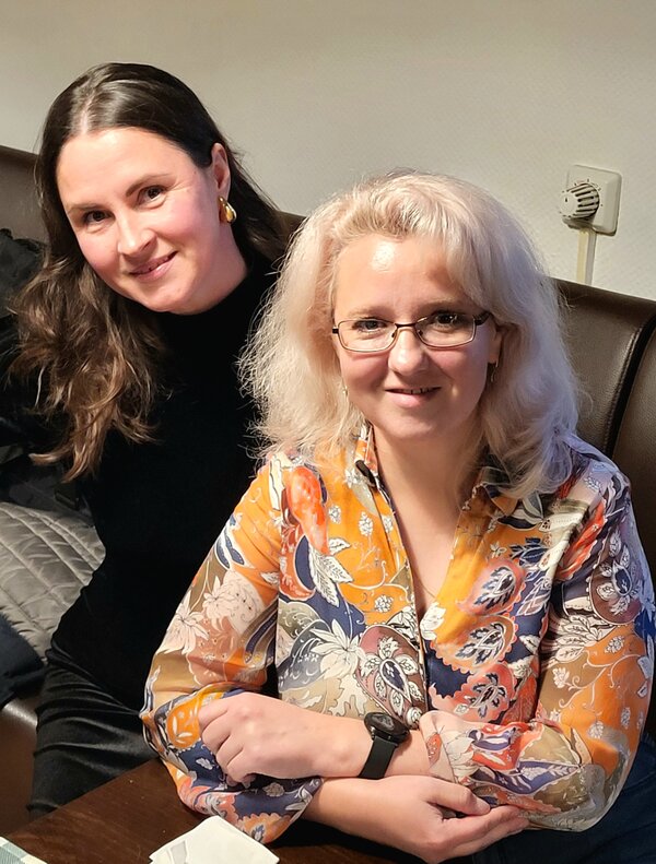 Zwei weibliche Mitarbeiterinnen der Euro-Schulen bzw. Euro Akademie, die zusammen an einem Tisch in einem Restaurant sitzen und etwas essen.