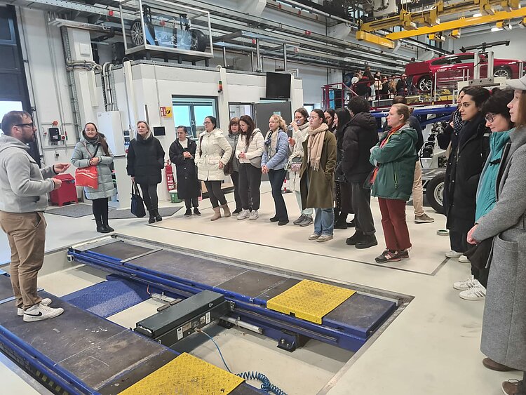Sonniger Exkursionstag der Euro-Schulen Dresden: Spannende Einblicke in Wissenschaft und Kultur Die Schülerinnen und Schüler stehen um eine Hebebühne herum und schauen bei einer Montage zu.
