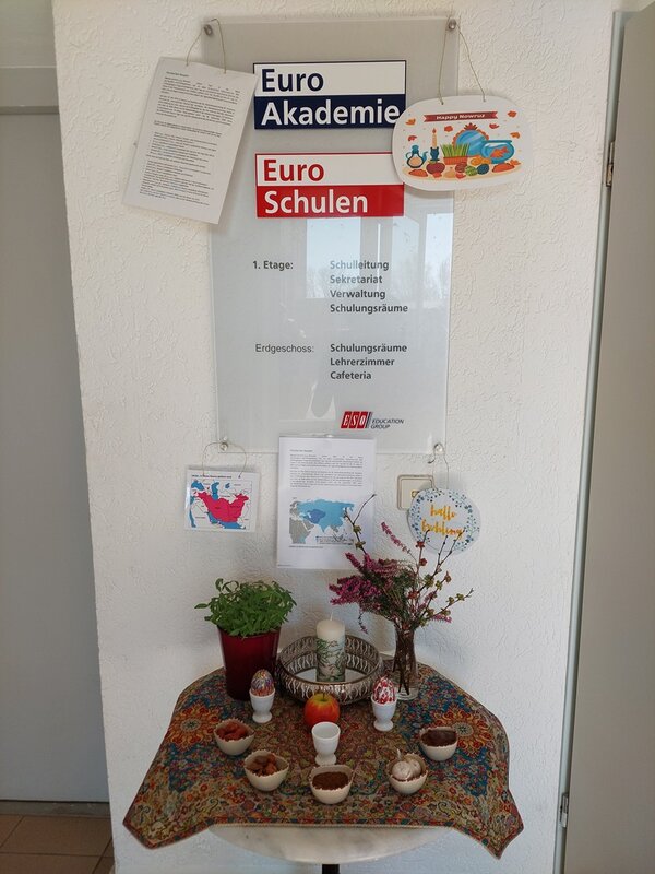 Ein sogenanter "Haft-Seen-Tisch" steht im Flur der Schule, auf dem  sieben symbolische Gegenstände stehen, die u. a. Gesundheit, Wohlstand, Glück symbolisieren.