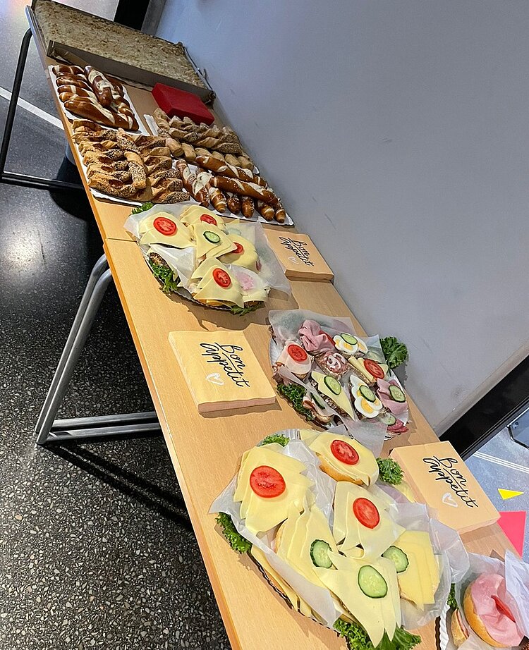 Erfolgreiches Bildungs-Speed-Dating Buffet mit belegten Broten mit Käse, Tomaten, Gurken, Ei, Schinken, Laugenstangen und einem Blechkuchen.
