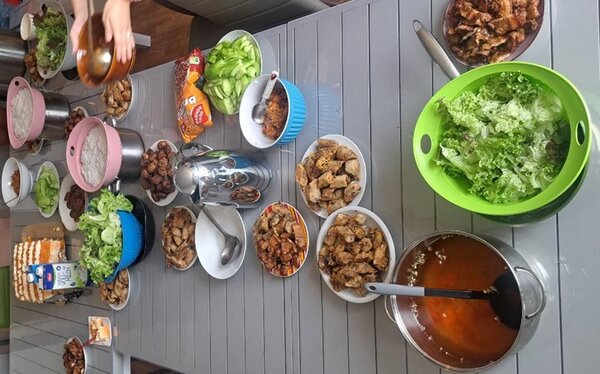 Lange gedeckte Tafel mit vietnamesischen Gerichten und Salaten. 