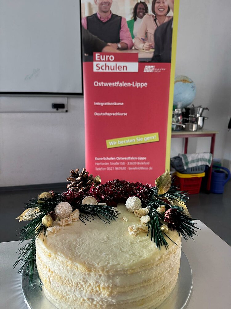 Festliche Weihnachtszeit bei den Euro-Schulen Ostwestfalen Ein weiße Torte mit verschiedenen Verzierungen.