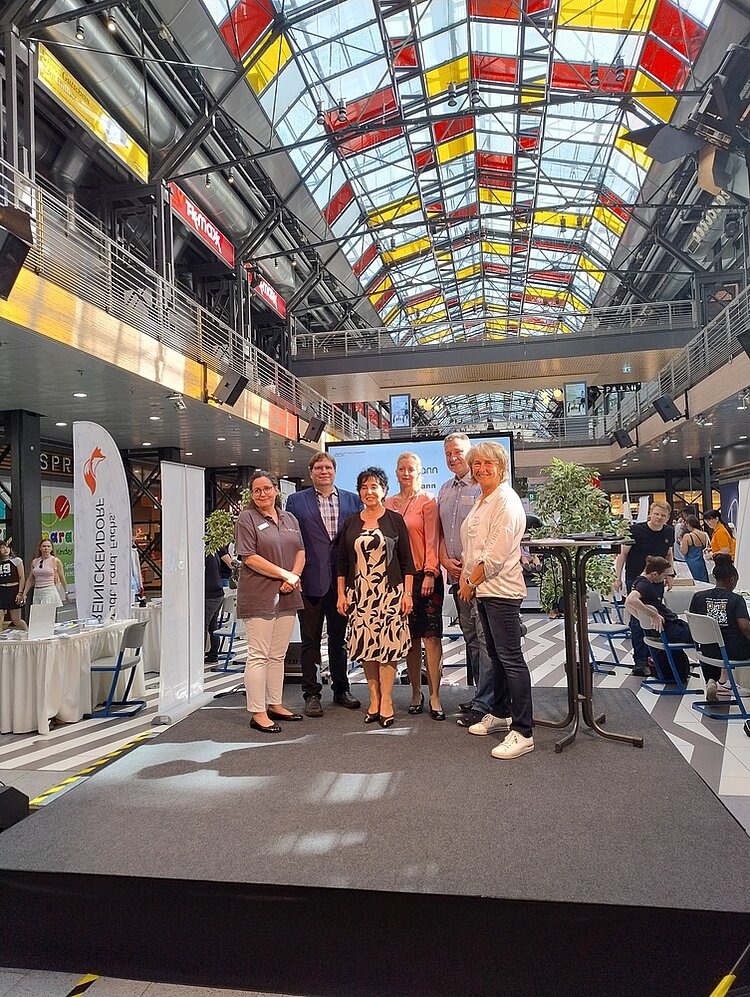 „Wege in die Ausbildung“ - Ein Tag voller Perspektiven für junge Menschen Die Organisator*innen der diesjährigen Informationsveranstaltung „Wege in die Ausbildung“ haben sich zu einem Gruppenfoto auf der Bühne positioniert.