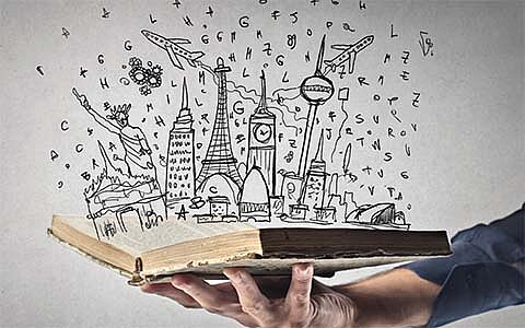 Eine Hand hält ein geöffnetes Buch, aus dem eine Vielzahl von gezeichneten Symbolen und Ikonen weltberühmter Sehenswürdigkeiten und Objekte wie der Eiffelturm, die Freiheitsstatue und musikalische Noten emporsteigen, was die Kraft der Fantasie und Bildung symbolisiert.