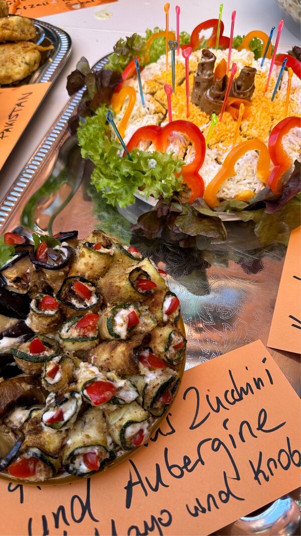 Appetitlich angerichtetes Gemüse auf Tellern mit Zetteln, was die einzelnen Buffetbeiträge enthalten