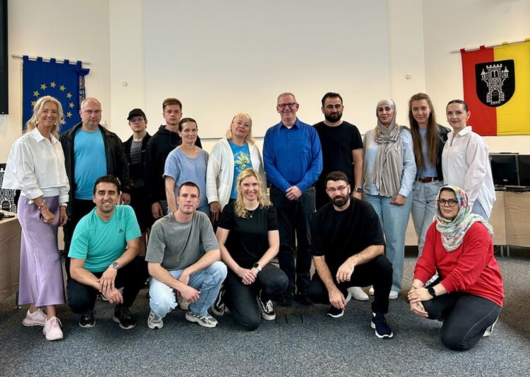 Die weiblichen und männlichen Teilnehmenden des Integrationskurses an den Euro-Schulen Menden posieren gemeinsam für ein Gruppenfoto im Rathaus Menden.