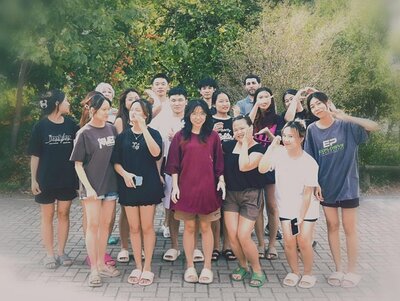 Die Kursteilnehmenden posieren bei sommerlichem Wetter gut gelaunt mit ihrer Dozentin für ein Gruppenfoto. 