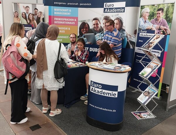 Messebesucherinnen und Messebesucher informieren sich am Euro Akademie Stand.