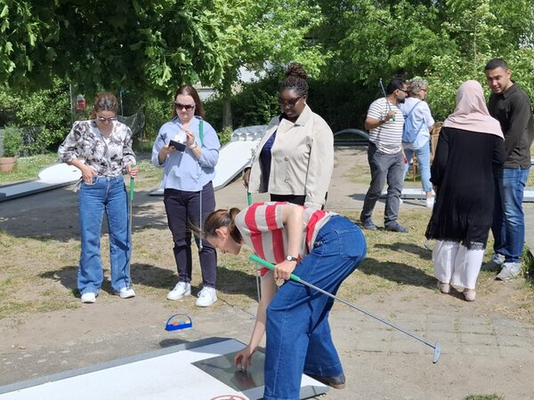 Mitarbeitende der Euro-Schulen stehen mit ihren Teams auf dem Minigolf-Platz und spielen um Platz 1.