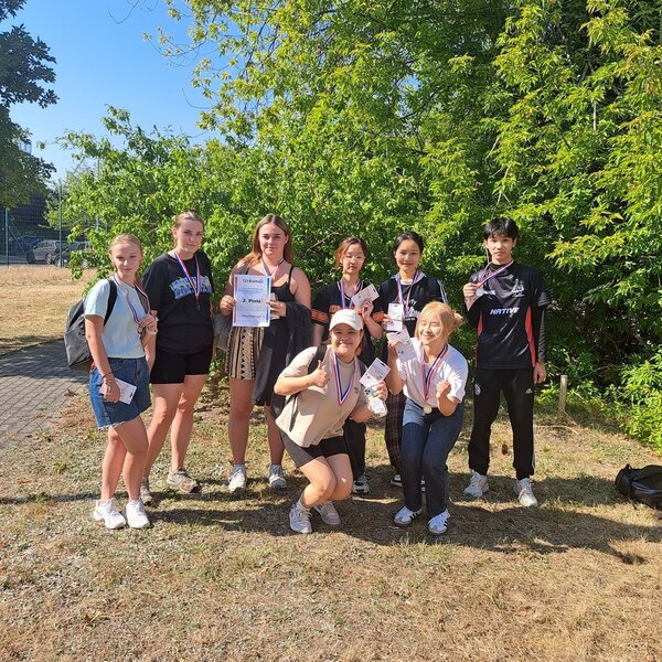 Die Zweitplatzierten posieren mit ihrer Urkunde und Medaillen um den Hals für ein Gruppenfoto.