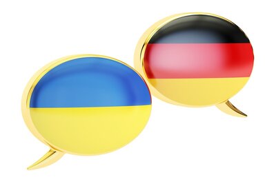 Grafik zweier Sprechblasen. Die Linke Sprechblase in den Farben Blau und Gelb der Ukraine, die rechte Sprechblase in den Farben Schwarz, Rot, Gold für Deutschland.