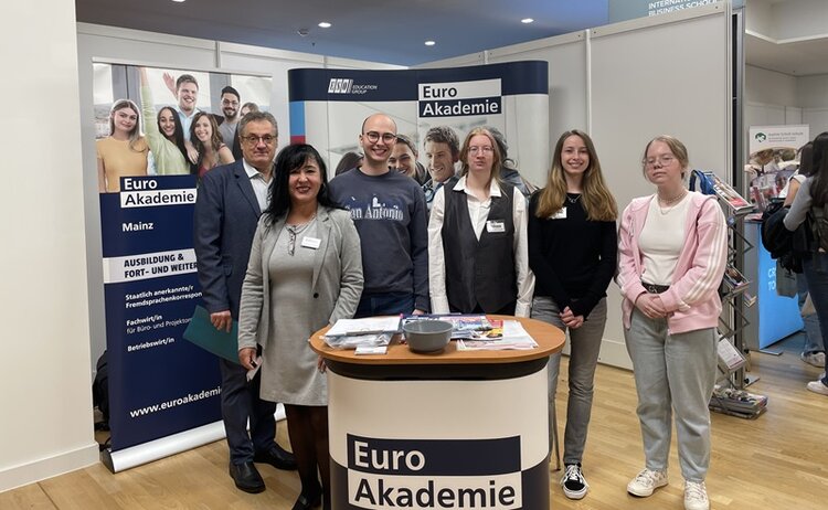Gruppenfoto am Euro Akademie Messestand mit sechs Teammitgliedern