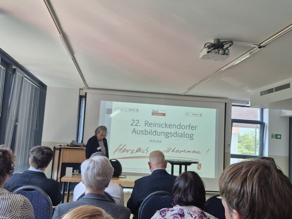 Blick ins Publikum beim 22. Reinickendorfer Ausbildungsdialog; auf der Leinwand steht „Herzlich willkommen!“.