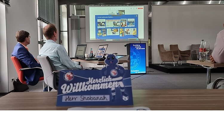 Erfolgreiches Gastspiel beim Sponsoren-Netzwerktreffen des 1. FFC Turbine Potsdam Blick in einen großen Raum, in dem das Sponsoren-Netzwerktreffen des 1. FFC Turbine Potsdam stattfand. Teilnehmende sitzen auf Stühlen, schauen eine Präsentation, die auf die Leinwand projiziert wird.