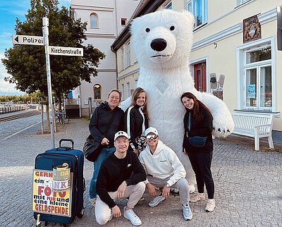 Abschlussfahrt der VK21 an die Ostsee Zu sehen Schülerinnen und Schüler des Ausflugs, die mit einem großen Eisbärkostüm posieren.