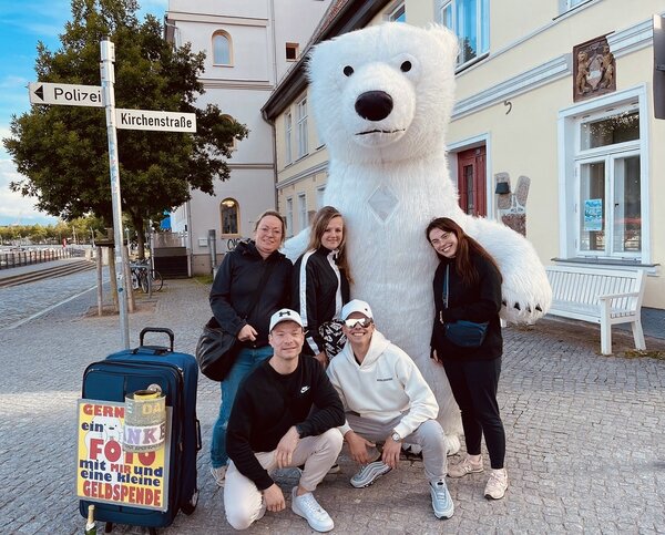 Zu sehen Schülerinnen und Schüler des Ausflugs, die mit einem großen Eisbärkostüm posieren.