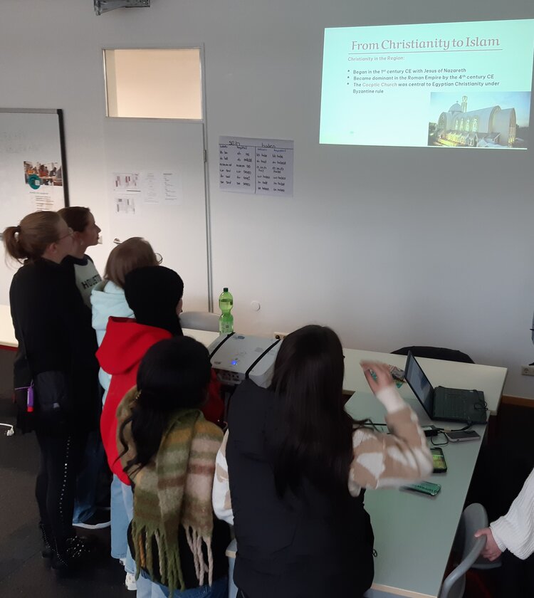 Schüler*innen und Interessent*innen stehen an Ständen des Intercultural Day an der Euro Akademie Mainz