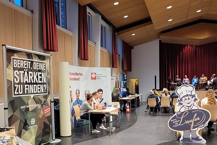 Lebhafte Podiumsdiskussion und Markt der Möglichkeiten Informationsstände mit Mitarbeitenden der teilnehmenden Unternehmen.