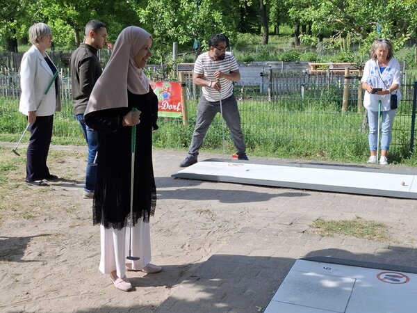 Mitarbeitende der Euro-Schulen auf dem Minigolf-Platz spielen in Teams gegeneinander. 