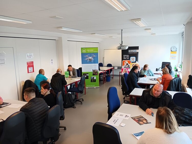 Teilnehmende sitzen potenziellen Arbeitgebern an Tischen gegenüber und lernen sich kennen.