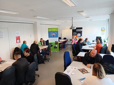 Teilnehmende sitzen potenziellen Arbeitgebern an Tischen gegenüber und lernen sich kennen.