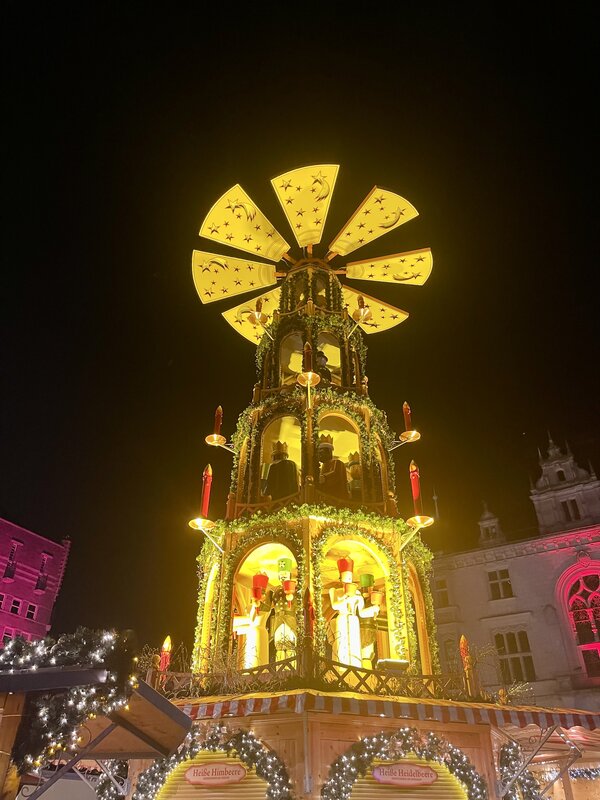 Foto der erleuchteten Weihnachtspyramide auf dem Hallescher Weihnachtsmarkt, im Hintergrund der nachtschwarze Himmel.