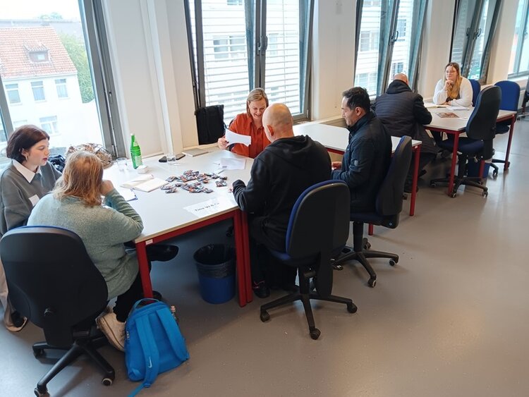 Teilnehmende sitzen mit Arbeitgebern an Tischen und lernen sich kennen.