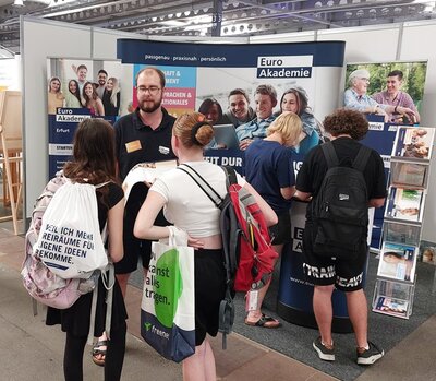 Interessierte Messebesucherinnen und Messebesucher lassen sich am Euro Akademie Stand beraten.