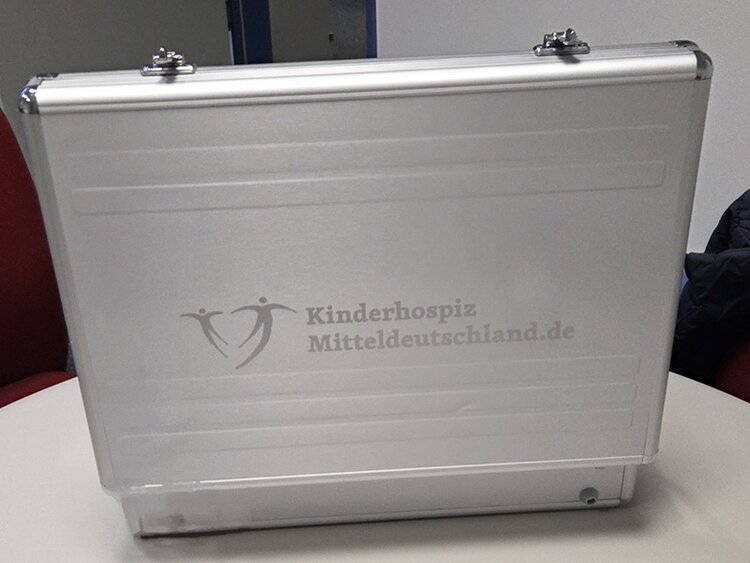 Ein geöffneter Aluminiumkoffer, auf dem der Schriftzug Kinderhospiz Mitteldeutschland.de steht