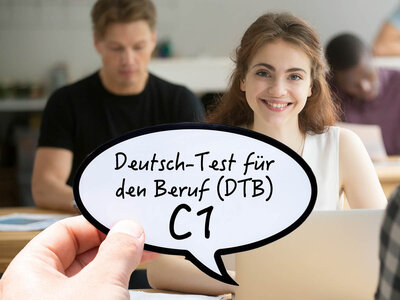 Eine Frau mit einem weißen Oberteil sitzt an einem Tisch und lächelt. Vor ihr schwebt eine Sprechblase mit dem Text 'Deutsch-Test für den Beruf (DTB) C1'. Im Hintergrund sind weitere Personen in einem Klassenzimmer oder Büro zu sehen, die an Tischen arbeiten.