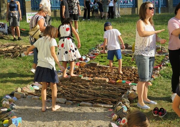 Kleine und große Besucher*innen bei der Erkundung des Sinnespfades. 