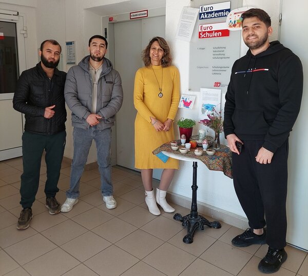 Teilnehmende und Lehrkraft stehen im Flur der Schule und posieren für ein Gruppenfoto.