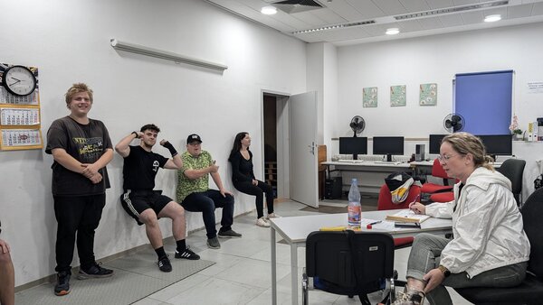 Ausdauer. Schüler müssen sich mit dem Rücken ohne Stuhl an eine Wand setzen und wer am längsten Durchhält bekommt die meisten Punkte.