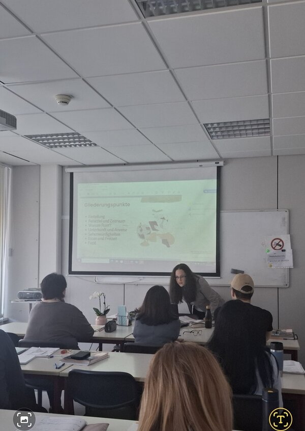 Eine Teilnehmende sitzt vorn am Whiteboard und trägt ihre Präsentation vor.