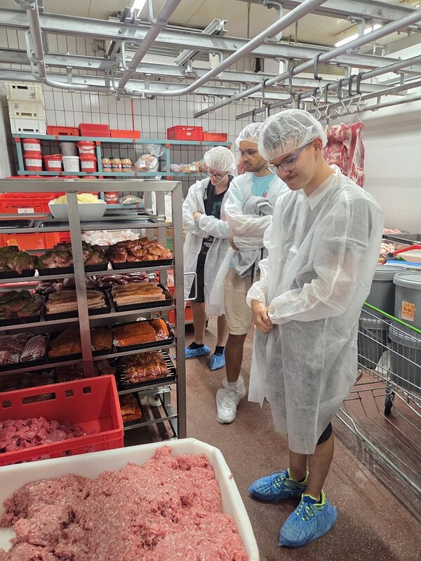 Azubis in Hygiene-Schutzkleidung in der Fleischerei.