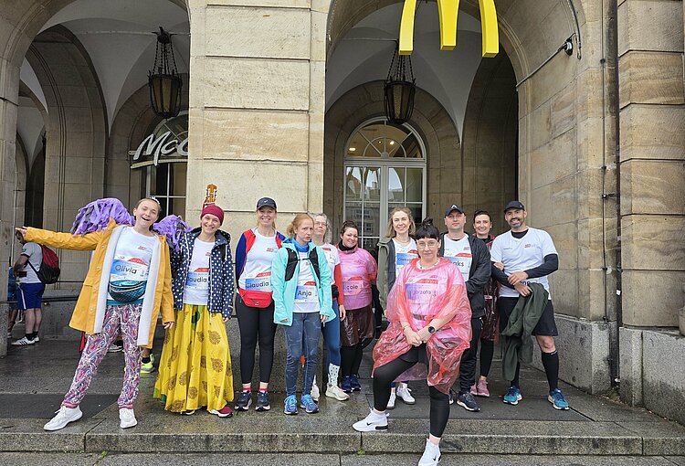Euro-Schulen & Euro Akademie bei der Rewe Team Challenge 2025 Gruppenfoto vor einem McDonald's-Bogen mit zwölf Teilnehmenden der REWE Team Challenge, darunter viele mit Startnummern und Namensschildern.