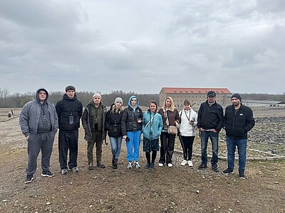 Besuch der Gedenkstätte Buchenwald Teilnehmende stehen zusammen für ein Gruppenbild auf dem Geländer der Gedenkstätte Buchenwald in Weimar.