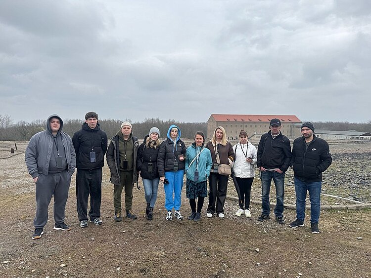 Besuch der Gedenkstätte Buchenwald Teilnehmende stehen zusammen für ein Gruppenbild auf dem Geländer der Gedenkstätte Buchenwald in Weimar.