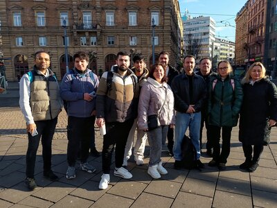 Junge Frauen und Männer stehen für ein Gruppenbild zusammen in der Mainzer Innenstadt.