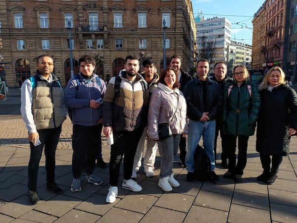 Junge Frauen und Männer stehen für ein Gruppenbild zusammen in der Mainzer Innenstadt.