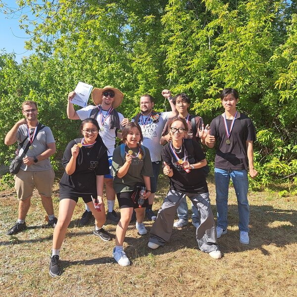 Die Siegermannschaft posiert mit ihrer Urkunde und Medaillen um den Hals für ein Gruppenfoto.