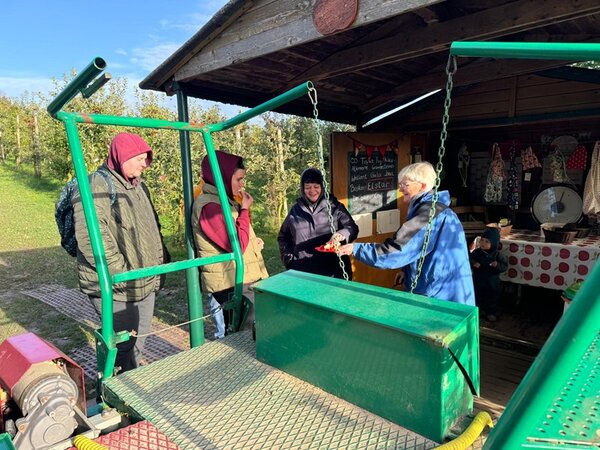 Teilnehmende stehen draußen auf dem Hofladen des Apfelgartens Linhorst.