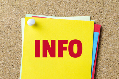 Die Aufschrift "Info" in großen roten Lettern steht auf einem gelben Zettel, der mit andern bunten Zetteln auf einer Pinwand angepinnt ist.